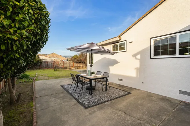 a view of a house with backyard and sitting area