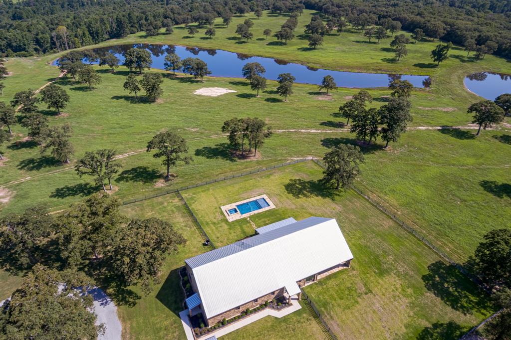 an aerial view of a house with a swimming pool yard and lake view