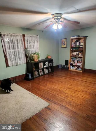 a living room with furniture and a dining table with wooden floor