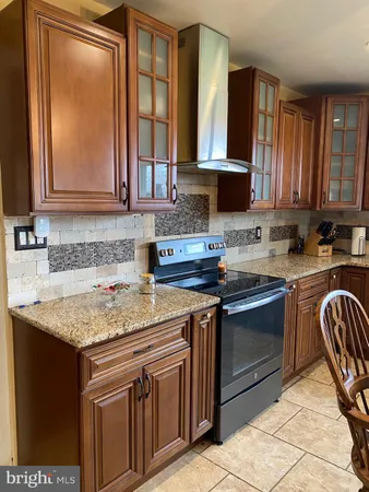 a kitchen with granite countertop a sink stove and cabinets
