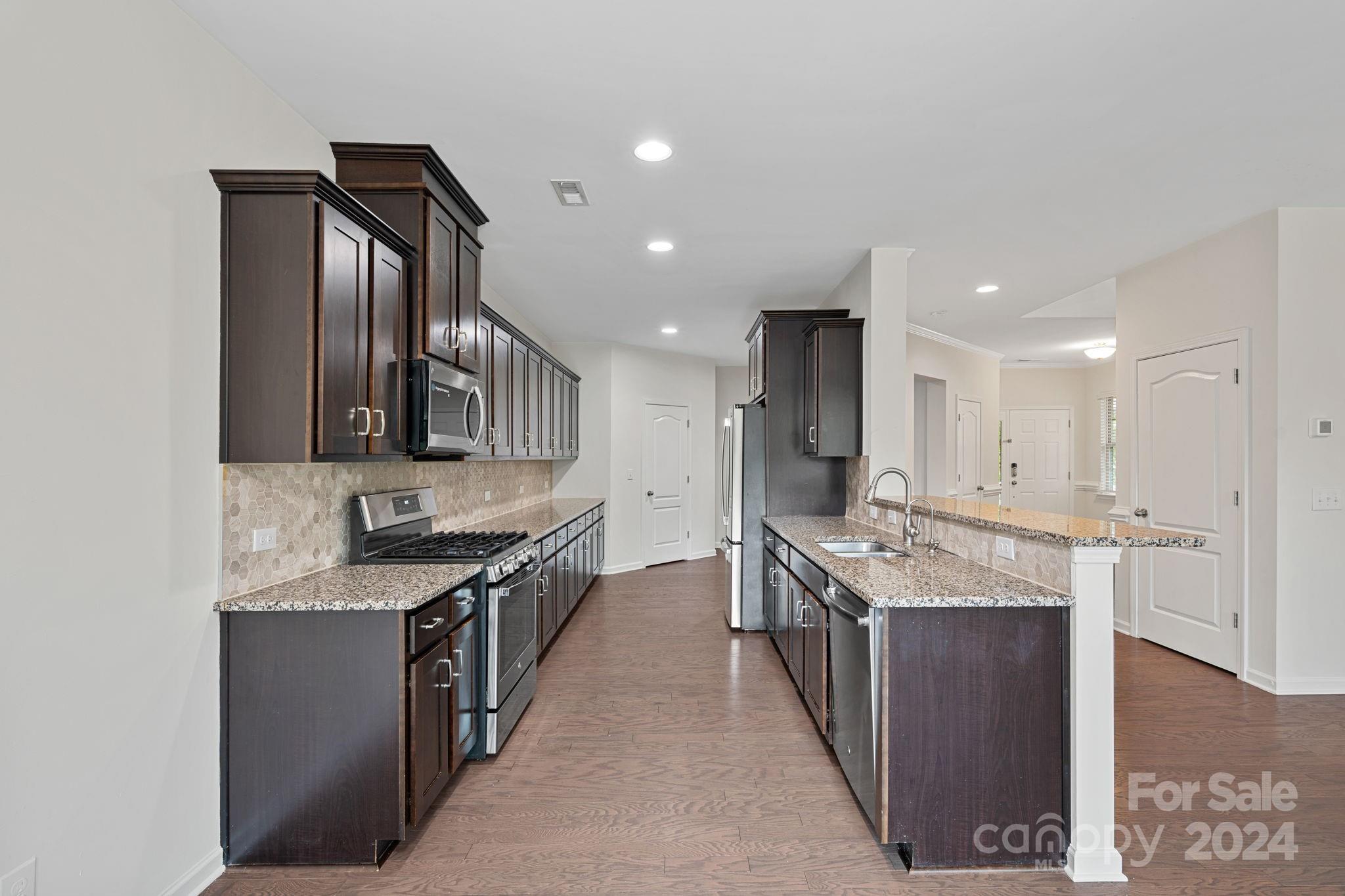 612 Amber Meadows Way Fort Mill, SC 29708 - Photo 26 of 34 a kitchen with stainless steel appliances granite countertop a sink stove and cabinets