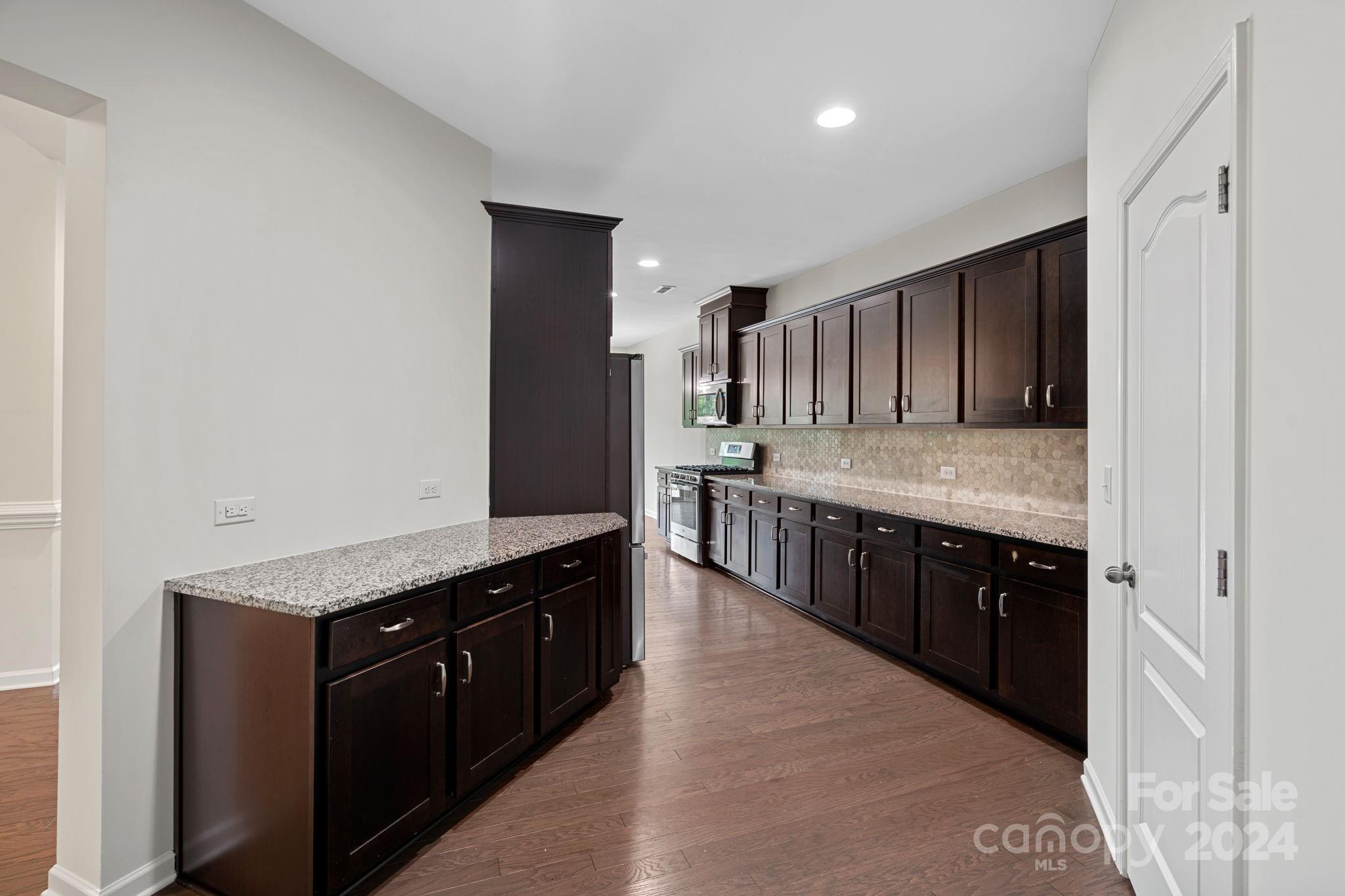 612 Amber Meadows Way Fort Mill, SC 29708 - Photo 7 of 34 a large kitchen with stainless steel appliances kitchen island granite countertop wooden cabinets and granite counter tops