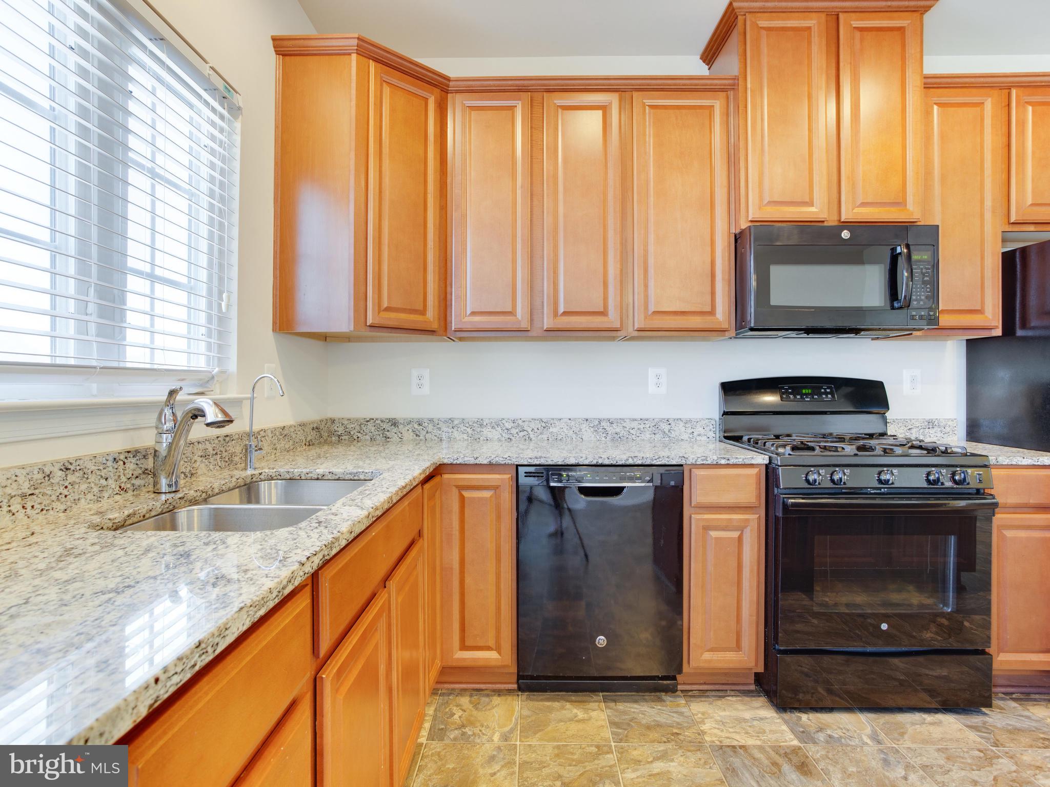 2416 Baileys Pond Road Accokeek, MD 20607 - Photo 8 of 52 a kitchen with stainless steel appliances granite countertop a stove a sink and a microwave