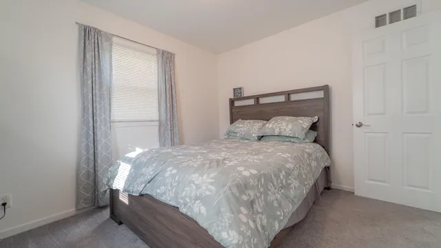 a bed sitting in a bedroom next to a window