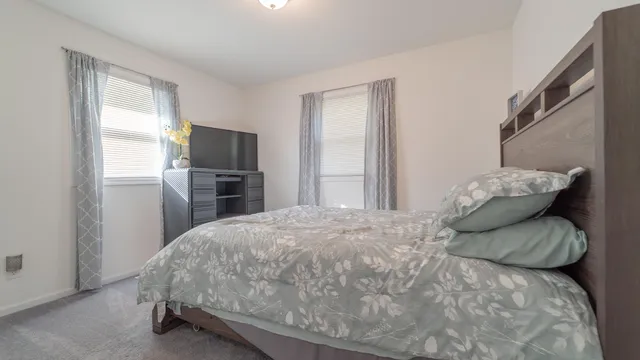 a bedroom with a bed and a refrigerator