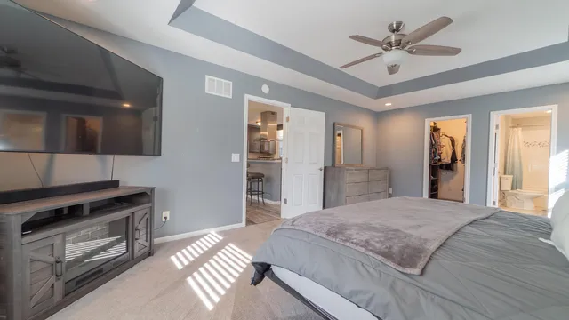 a spacious bedroom with a bed and a chandelier