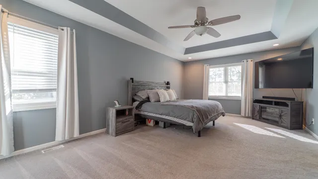 a spacious bedroom with a bed and a flat screen tv