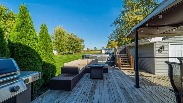 a view of a patio with table and chairs under an umbrella with wooden floor