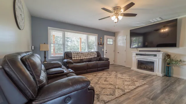 a living room with furniture a fireplace and a flat screen tv