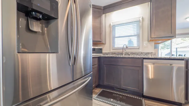 a kitchen with stainless steel appliances granite countertop a refrigerator and a sink