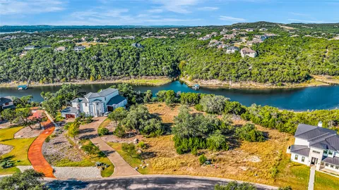 an aerial view of a residential houses covered in trees and flowers