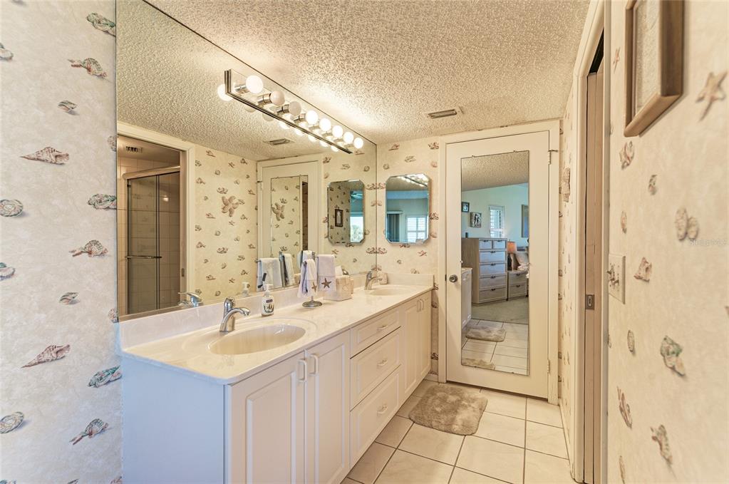 4825 Gulf Of Mexico Drive, Unit 201 Longboat Key, FL 34228 - Photo 14 of 42 a spacious bathroom with a shower sink and mirror