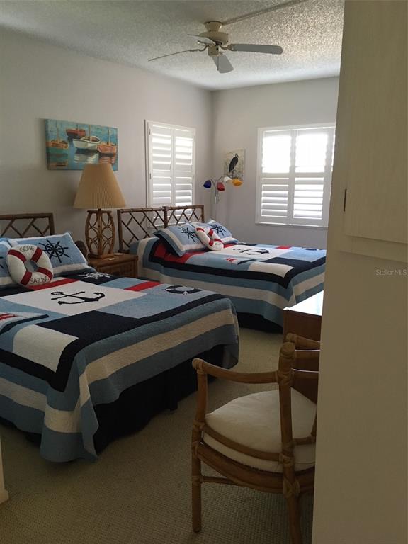 4825 Gulf Of Mexico Drive, Unit 201 Longboat Key, FL 34228 - Photo 19 of 42 a bedroom with a bed and windows