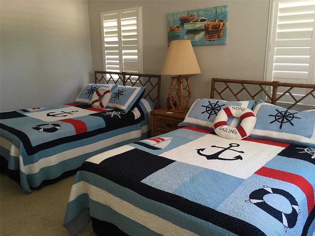 4825 Gulf Of Mexico Drive, Unit 201 Longboat Key, FL 34228 - Photo 20 of 42 a bedroom with a bed and a wooden floor