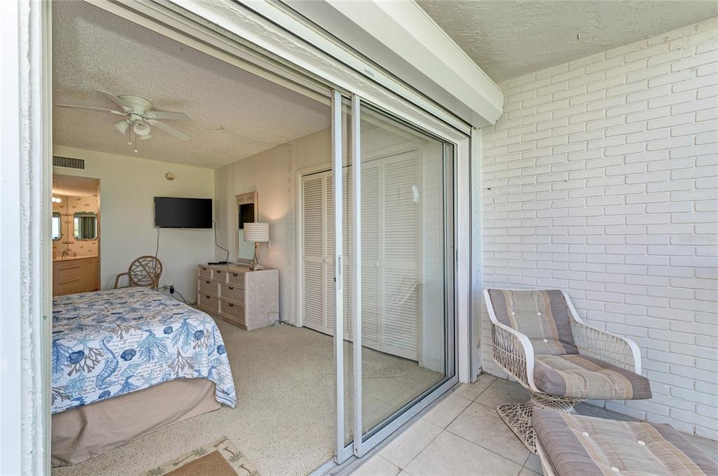 4825 Gulf Of Mexico Drive, Unit 201 Longboat Key, FL 34228 - Photo 25 of 42 a bedroom with a bed and a flat screen tv