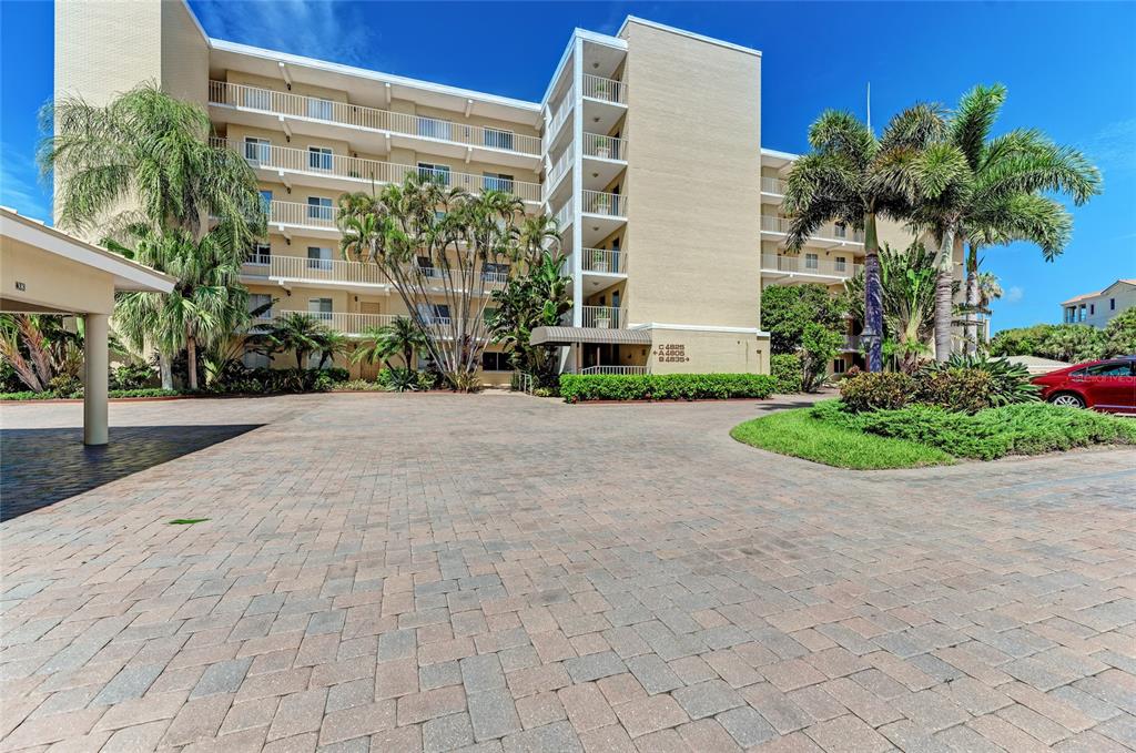 4825 Gulf Of Mexico Drive, Unit 201 Longboat Key, FL 34228 - Photo 28 of 42 a front view of a house with a yard and a garage