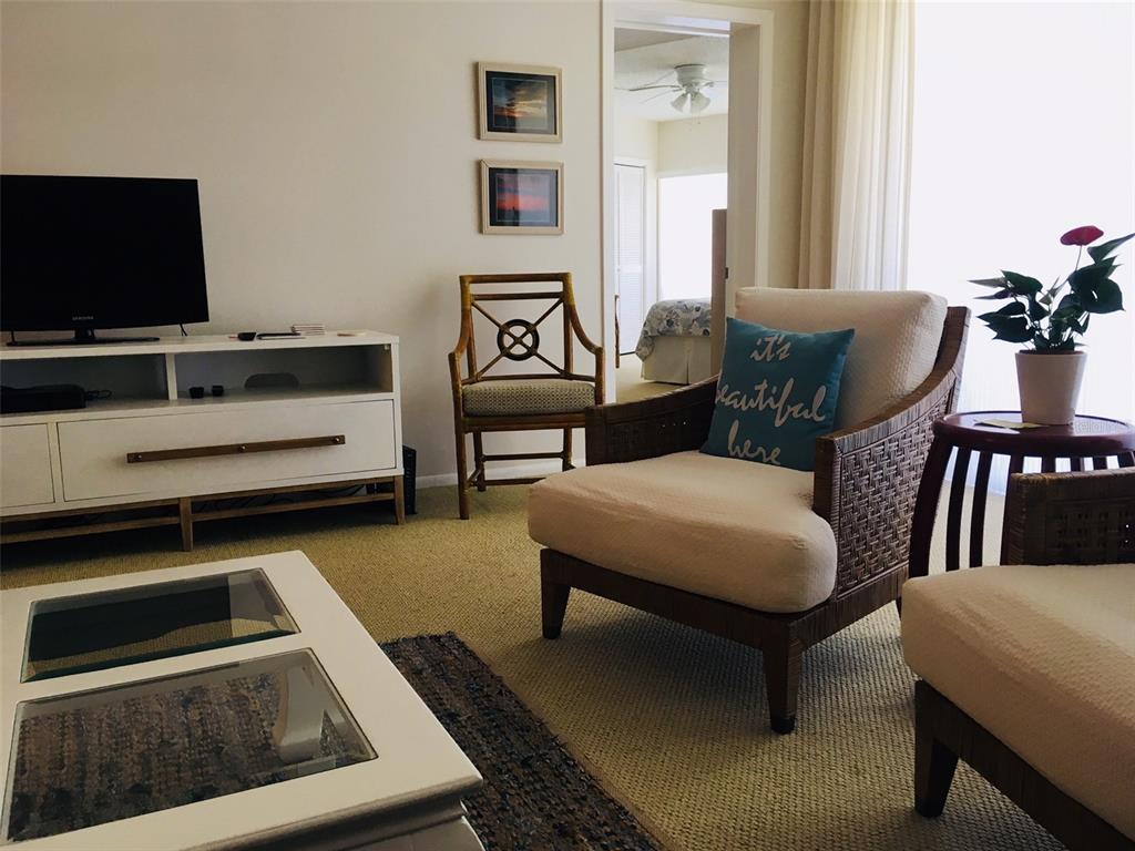 4825 Gulf Of Mexico Drive, Unit 201 Longboat Key, FL 34228 - Photo 3 of 42 a living room with furniture and a flat screen tv