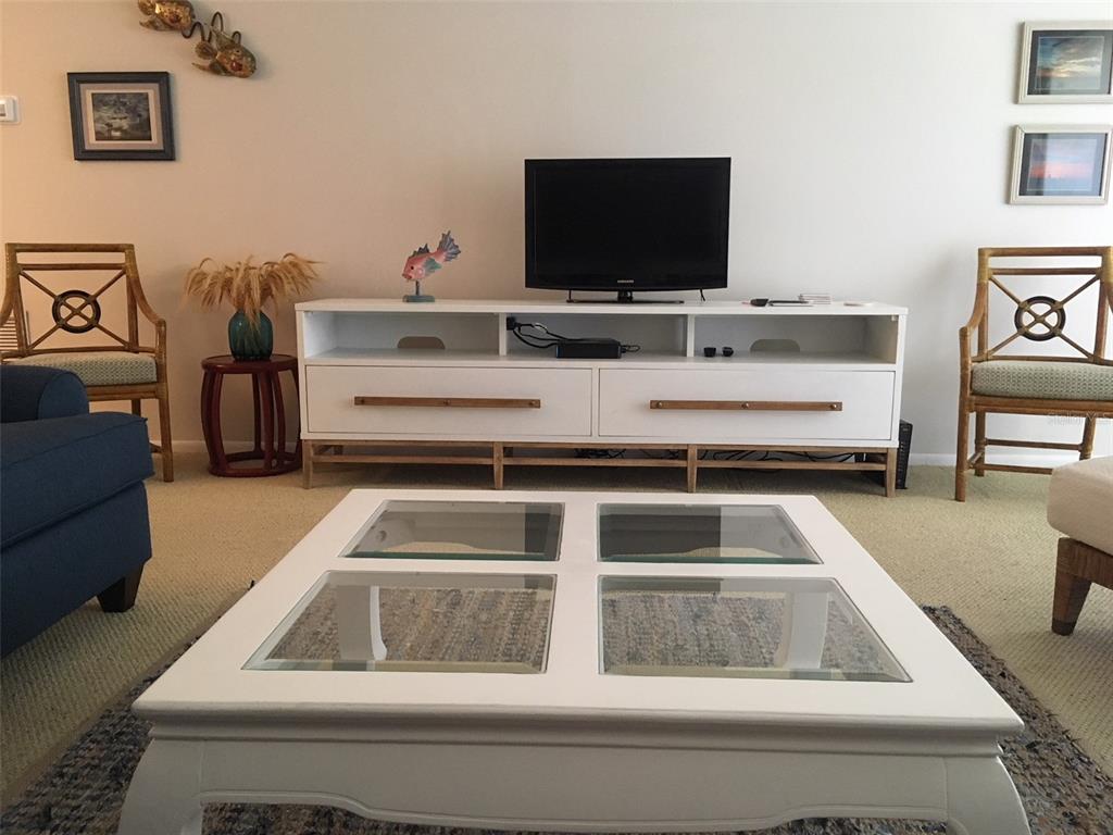 4825 Gulf Of Mexico Drive, Unit 201 Longboat Key, FL 34228 - Photo 7 of 42 a living room with furniture and a flat screen tv