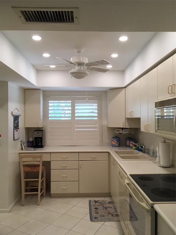 4825 Gulf Of Mexico Drive, Unit 201 Longboat Key, FL 34228 - Photo 8 of 42 a kitchen with a stove a sink and a refrigerator