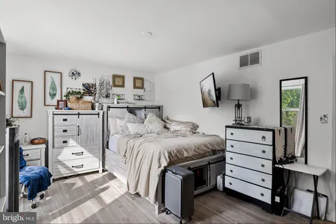 a bedroom with a bed and a flat tv screen on the dresser