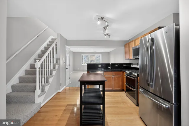 a kitchen with stainless steel appliances granite countertop a refrigerator a stove and a refrigerator