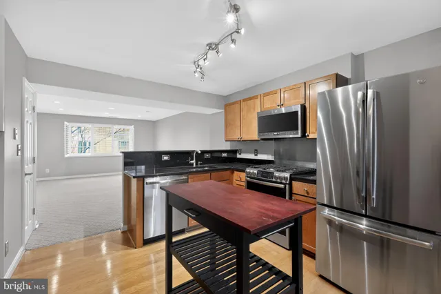 a kitchen with stainless steel appliances a stove a refrigerator and a sink