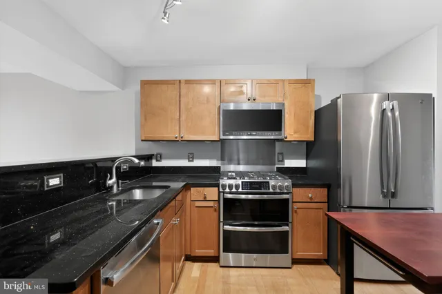 a kitchen with stainless steel appliances a sink stove and refrigerator