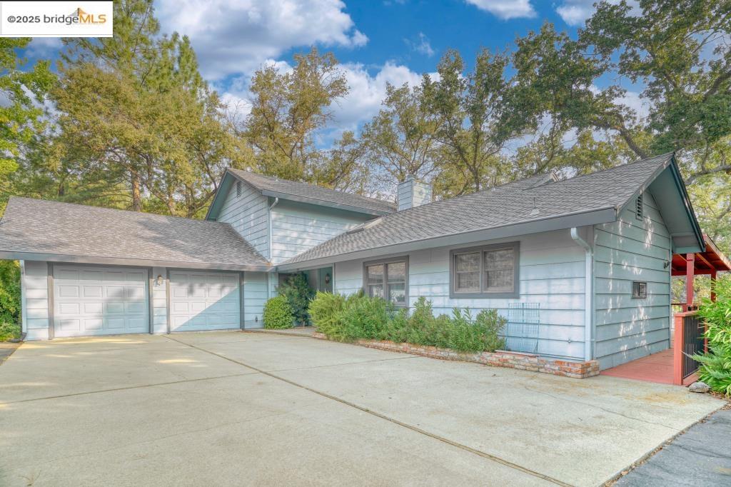 19195 Ferretti Road Groveland, CA 95321 - Photo 1 of 51 View of front facade with an attached garage, a shingled roof, concrete driveway, and a chimney