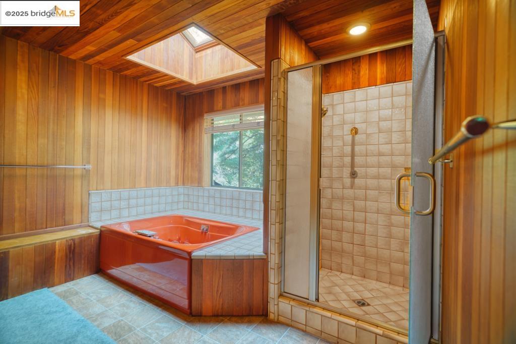 19195 Ferretti Road Groveland, CA 95321 - Photo 15 of 51 Bathroom with a skylight, a stall shower, cedar walls and ceiling, and a jetted tub.