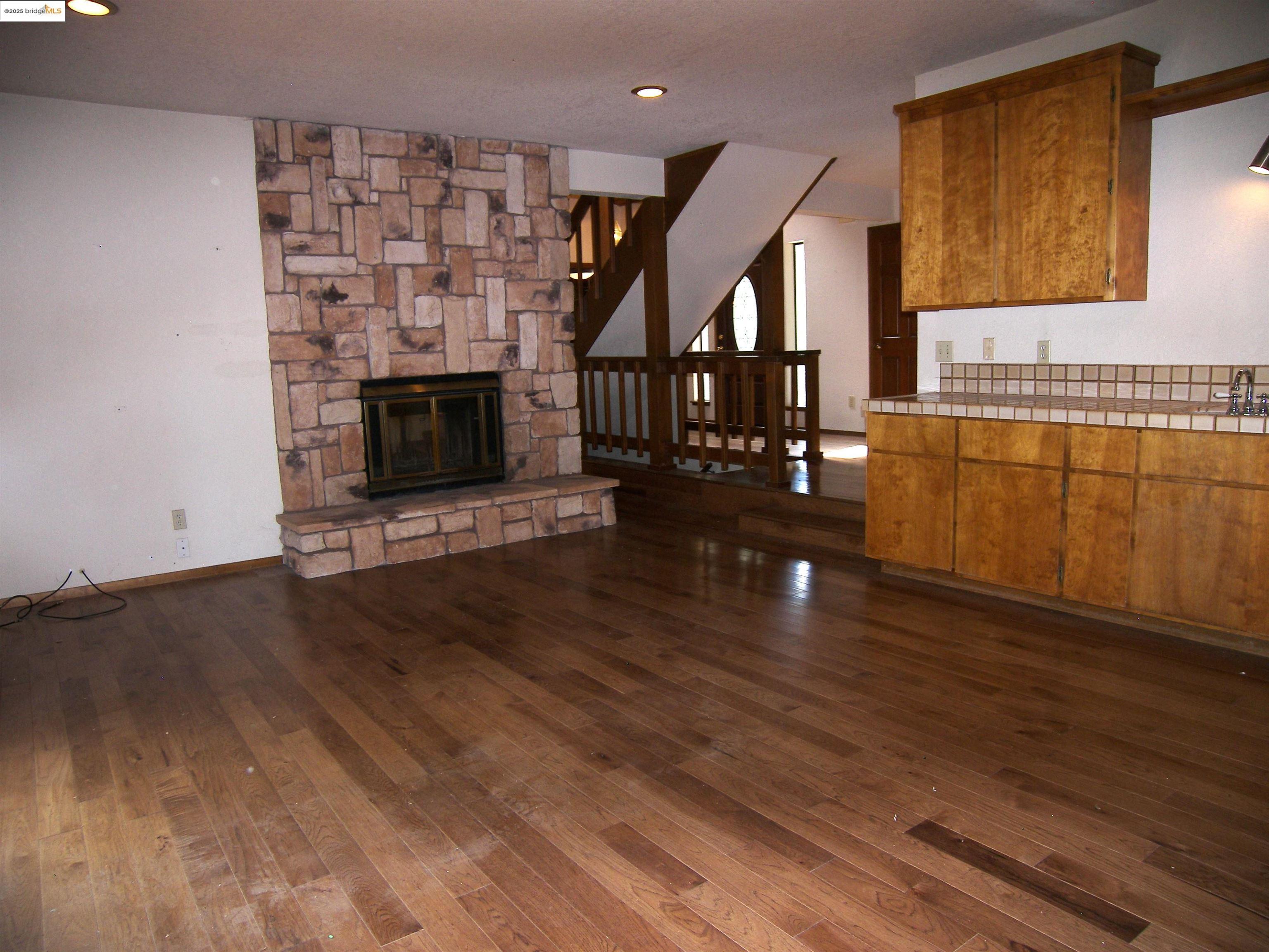 19195 Ferretti Road Groveland, CA 95321 - Photo 45 of 51 Unfurnished family room with dark wood-style floors, a stone fireplace, and recessed lighting, nice tile wet bar & cabinets.