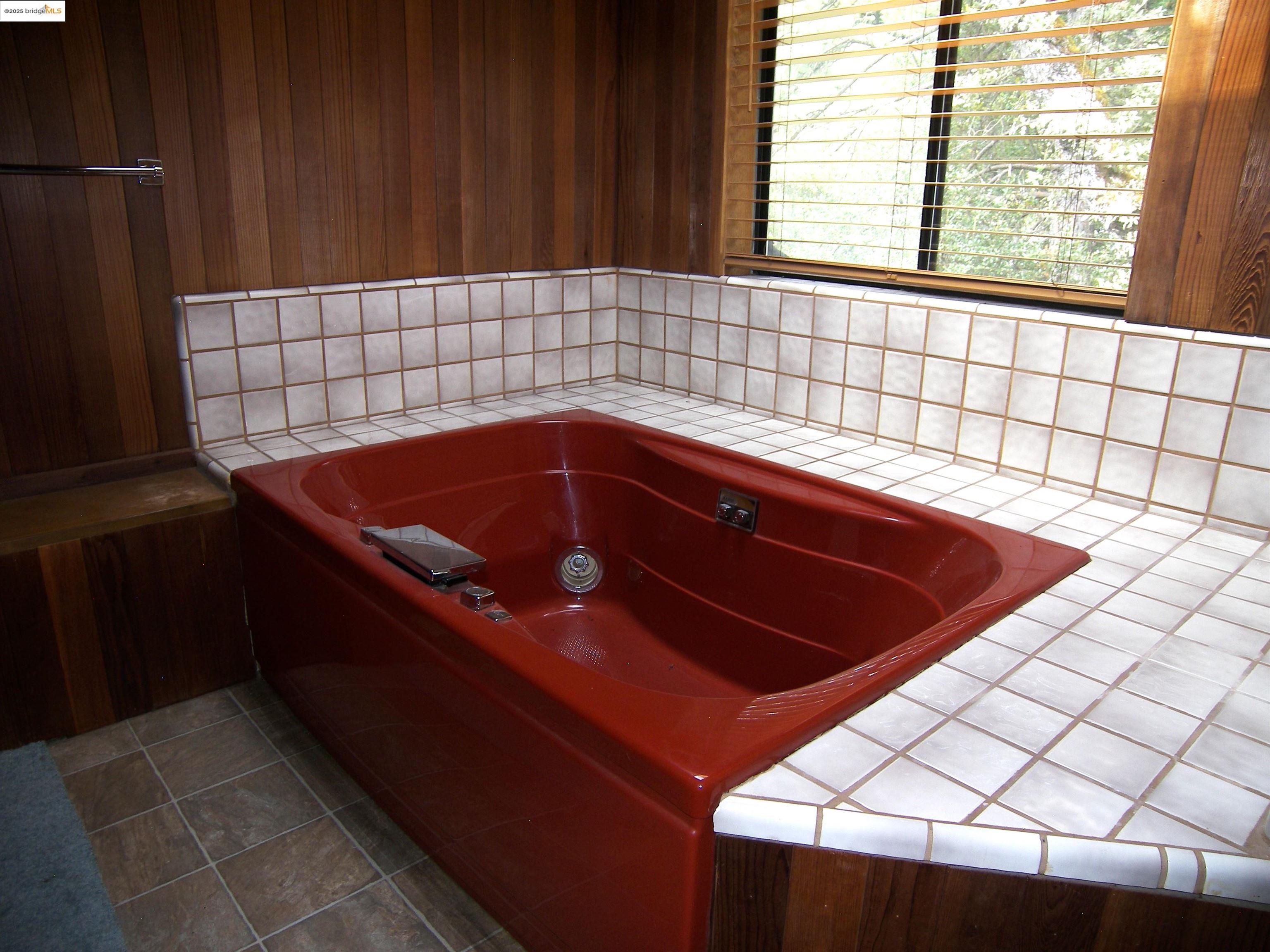 19195 Ferretti Road Groveland, CA 95321 - Photo 47 of 51 Bathroom with a jetted tub, tile patterned flooring, and wooden walls