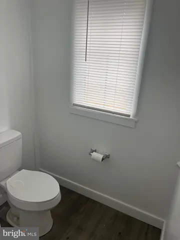 a bathroom with a toilet a window and a shower