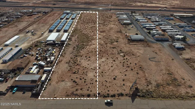 a view of a dry yard with wooden fence