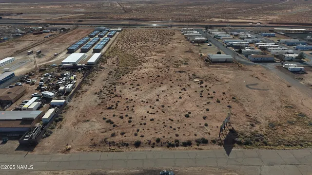 a view of a dry yard with wooden fence