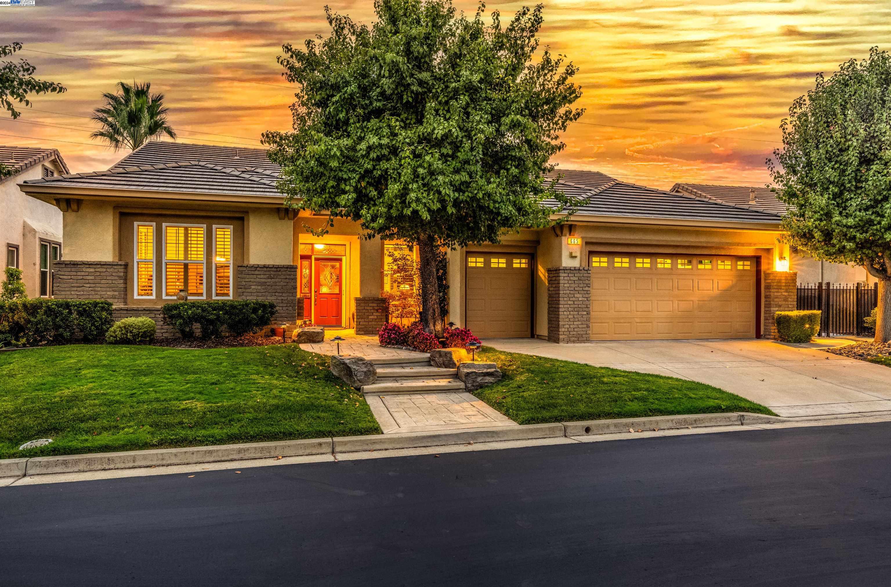 a front view of a house with a yard and potted plants