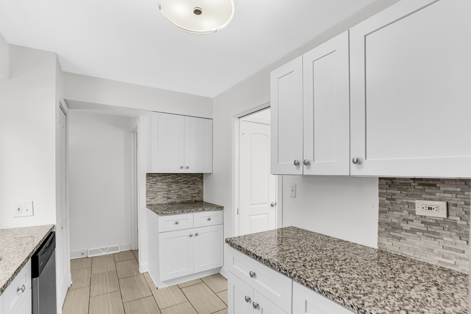 503 Ridge Road, Unit 21 Wilmette, IL 60091 - Photo 15 of 21 a kitchen with granite countertop white cabinets and stainless steel appliances