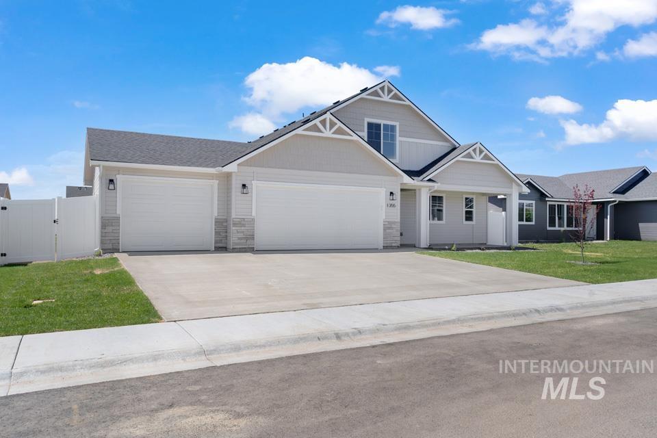 1355 Crescent Street Weiser, ID 83672 - Photo 30 of 31 Craftsman-style home featuring an attached garage, driveway, a gate, and stone siding