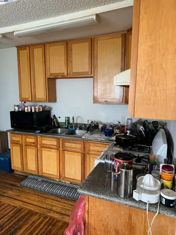 a kitchen with a sink and a stove top open