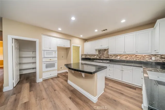 a view of a kitchen with white cabinets