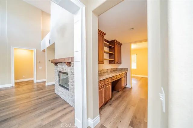 an empty room with a chandelier fan and windows