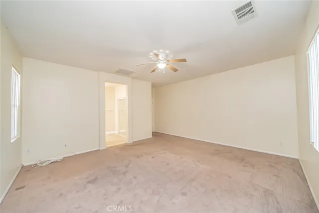 an empty room with closet and windows