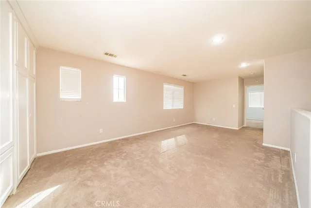 an empty room with windows and fan