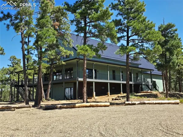 a front view of a house with a tree