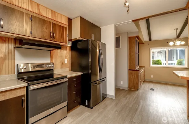 a kitchen with a refrigerator stove and wooden cabinets