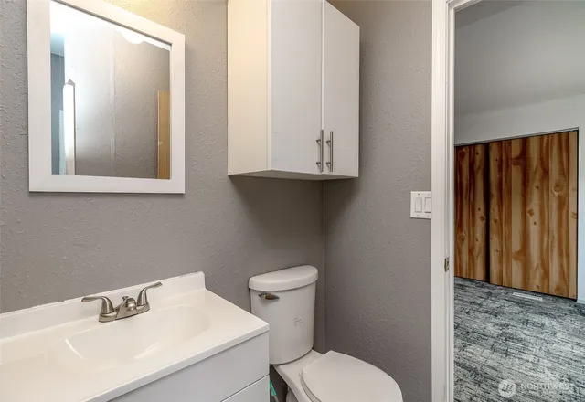 a bathroom with a toilet sink and mirror