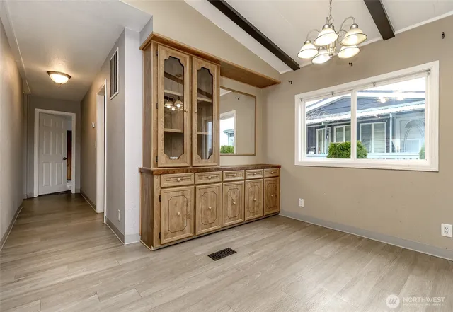 a view of a hallway with wooden floor and a kitchen