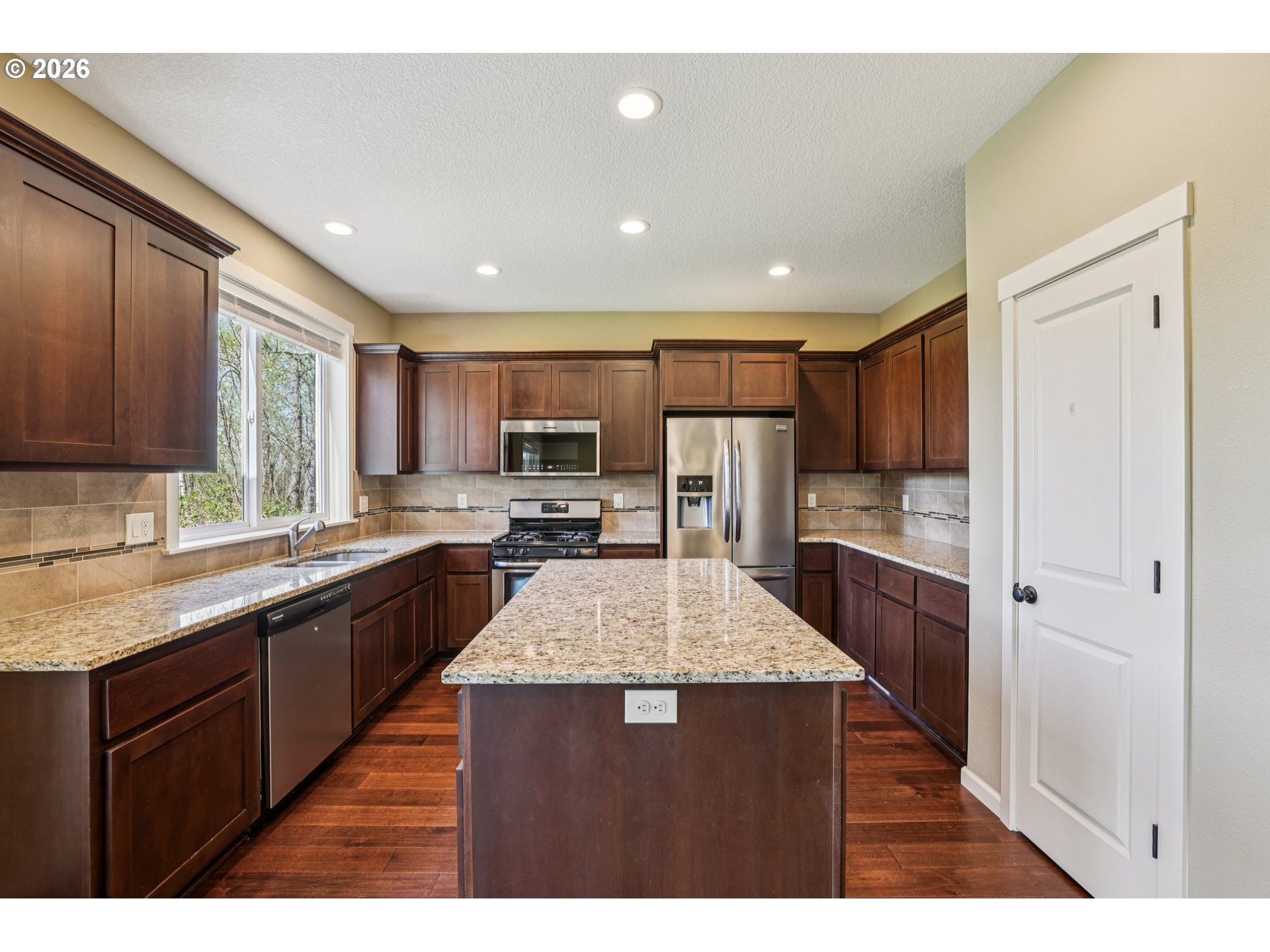 2117 Southeast Cochran Drive Gresham, OR 97080 - Photo 20 of 48 a large kitchen with stainless steel appliances kitchen island granite countertop a large counter top and wooden cabinets