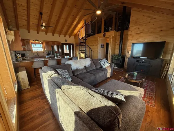 a living room with furniture a fireplace and wooden floor