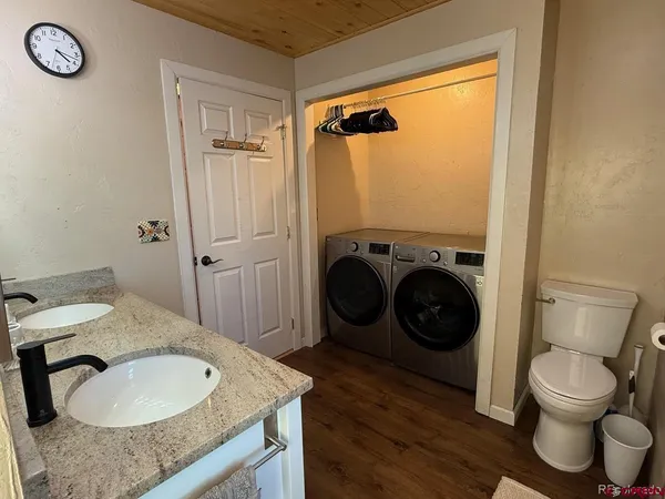 a bathroom with a granite countertop toilet a sink and a mirror