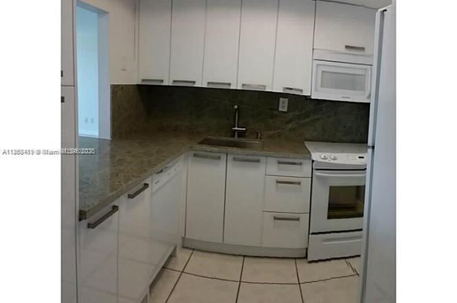 5401 Collins Avenue, Unit 829 Miami Beach, FL 33140 - Photo 19 of 29 a kitchen with a stove and white cabinets